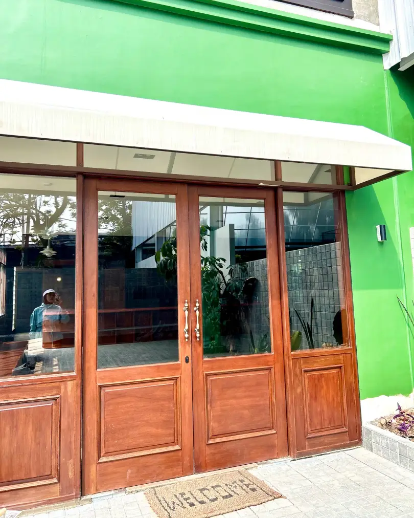 Timber doors on a green facade